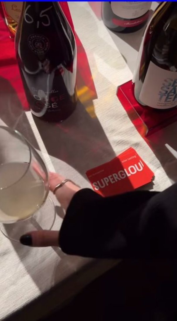 Wijnflessen en een Superglou-kaart op een eventtafel